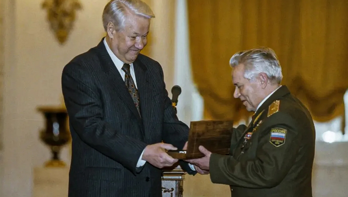 Президент России Борис Ельцин вручает Михаилу Калашникову наградное оружие