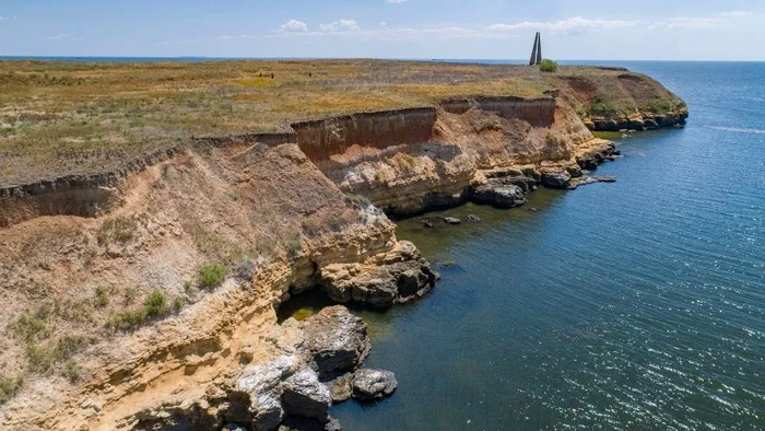 В толще отвесных берегов Березани таится множество исторических артефактов. На фото вдали — памятник лейтенанту Шмидту