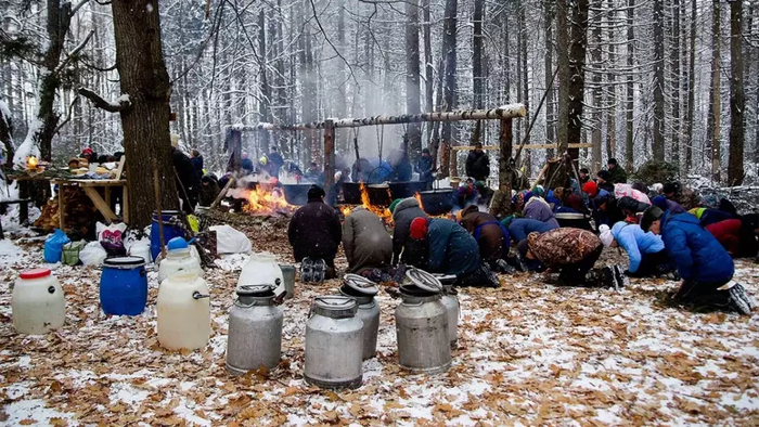 Люди молятся на коленях, предварительно постелив еловые ветки