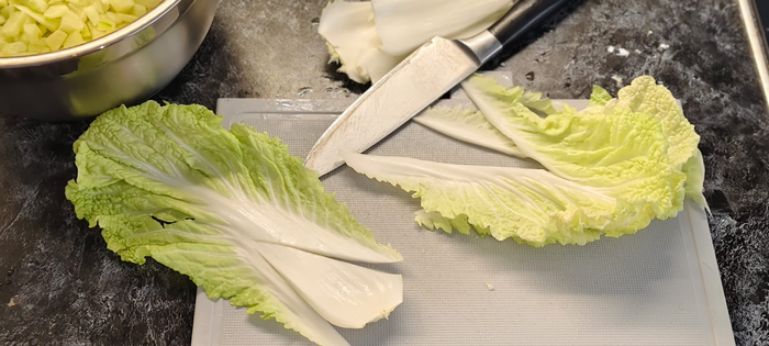 У пекинской капусты срезаю толстую часть (она в дело не пойдёт) . Мелко режу оставшееся.