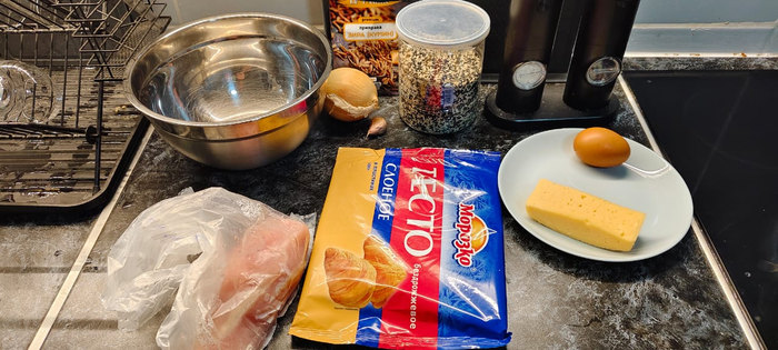 Куриная грудка, слоеное тесто, лук, чеснок, сыр, яйцо, кунжутные семечки, зира, соль перец. ( Ещё муку забыл добавить, но она чисто на стол при работе с тестом посыпать)