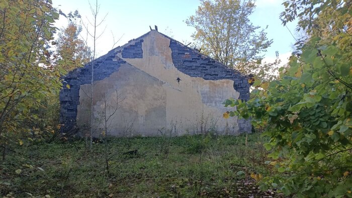 вот стенка снаружи. Видны останки плаца и тень от пристройки.