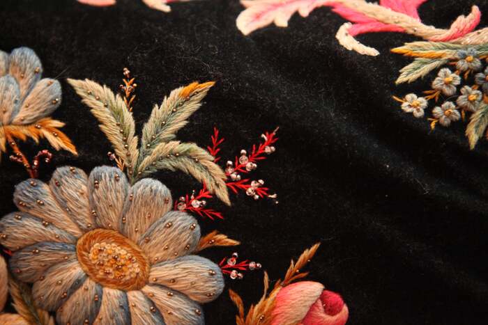 Здесь вверху справа виден повторяющийся мотив на каждом из углов подушки: незабудки и длинные розовые листья.